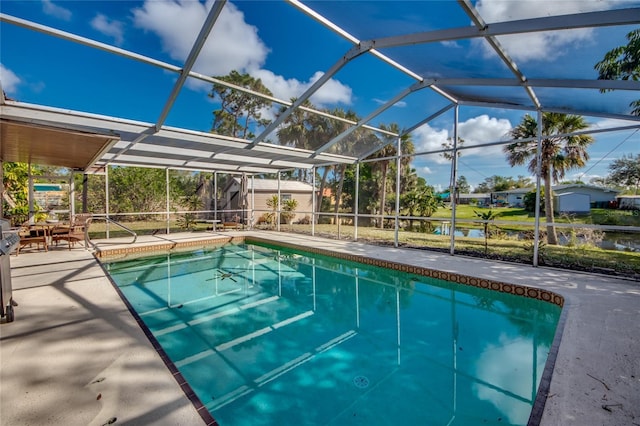 view of swimming pool featuring glass enclosure and a patio area