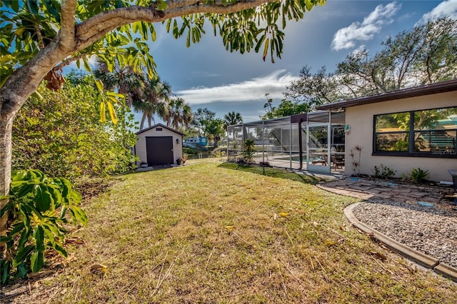 view of yard with glass enclosure, a patio, and a storage unit