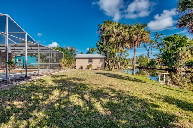 view of yard with a lanai and a water view