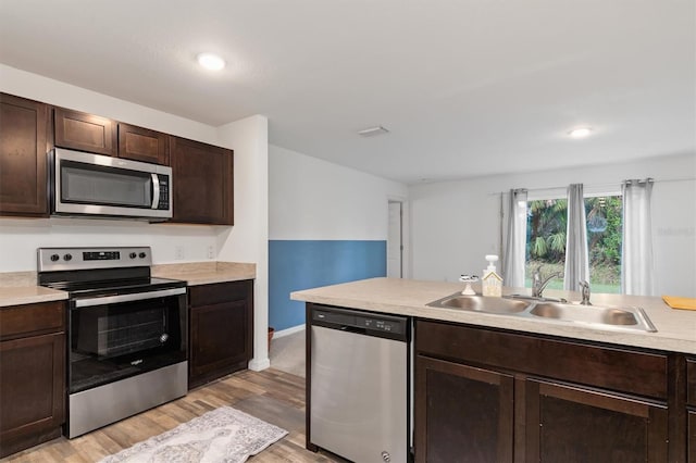 kitchen with dark brown cabinetry, sink, appliances with stainless steel finishes, and light hardwood / wood-style flooring