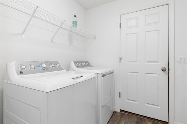 laundry area with washer and dryer and dark wood-type flooring