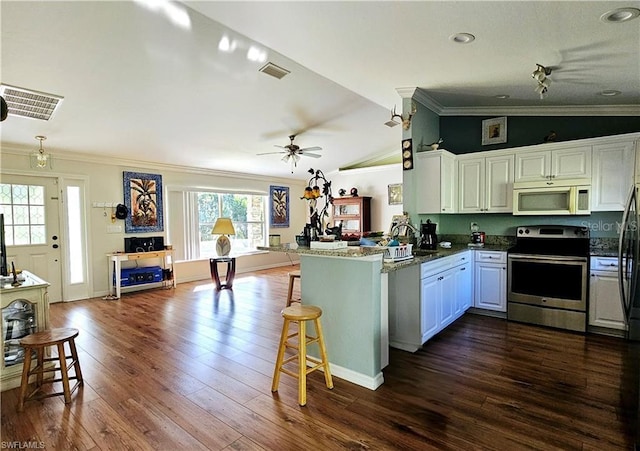 kitchen with lofted ceiling, crown molding, kitchen peninsula, and stainless steel range with electric cooktop