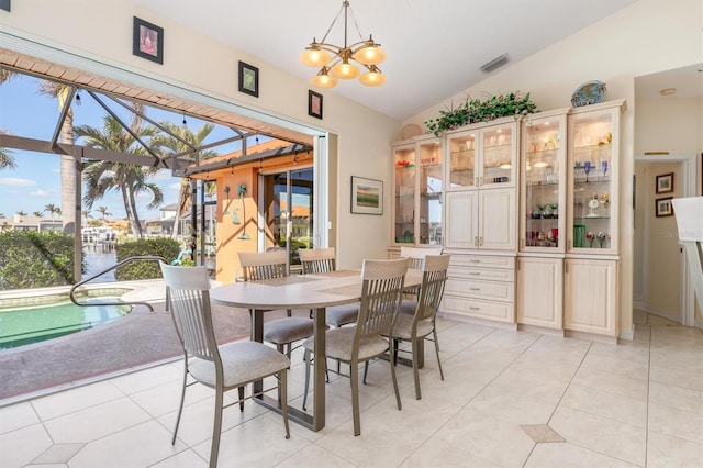 tiled dining space featuring lofted ceiling and an inviting chandelier