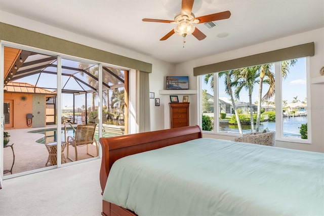 carpeted bedroom featuring ceiling fan and a water view