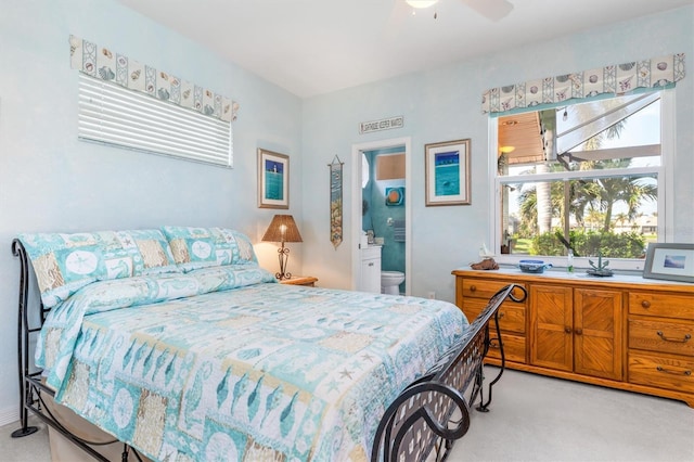 bedroom featuring ensuite bathroom, ceiling fan, and light carpet