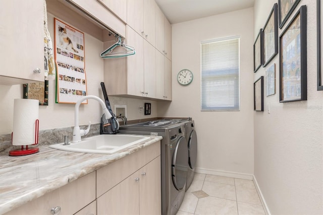 washroom featuring light tile patterned flooring, cabinets, sink, and washing machine and clothes dryer