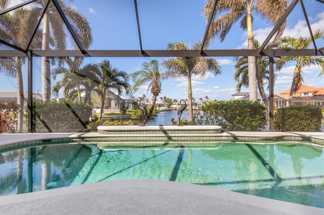 view of swimming pool with a lanai and a water view