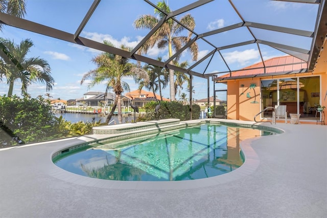 view of swimming pool featuring glass enclosure, a water view, and a patio