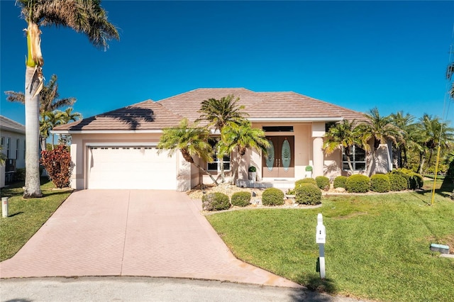 view of front of property with french doors, a front lawn, and a garage