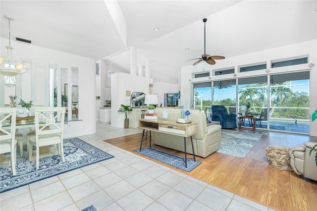 living room with light hardwood / wood-style floors, vaulted ceiling, and ceiling fan