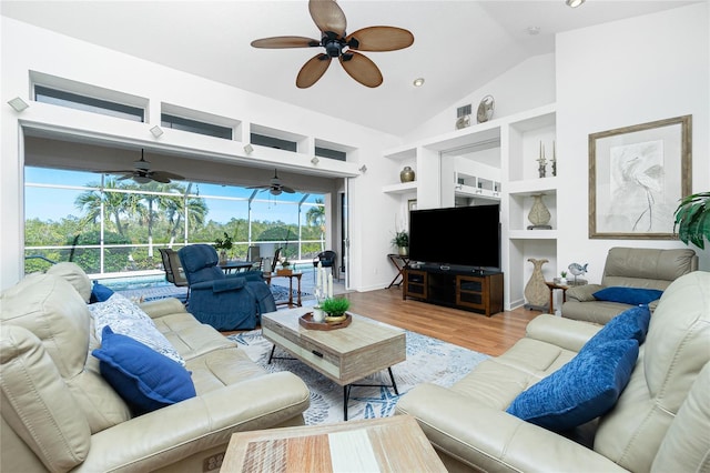 living room featuring built in shelves, hardwood / wood-style floors, a wealth of natural light, and lofted ceiling