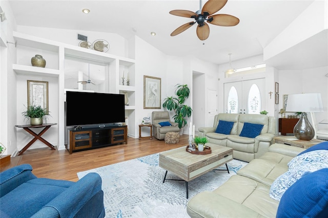 living room with hardwood / wood-style floors, plenty of natural light, french doors, and vaulted ceiling