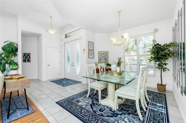 dining area with light tile patterned floors and an inviting chandelier