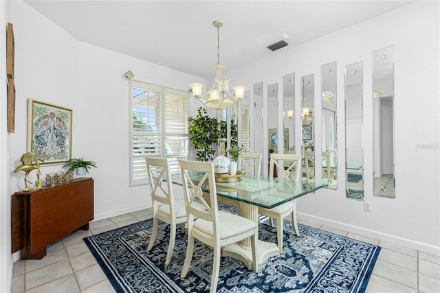 dining area with a chandelier and light tile patterned floors