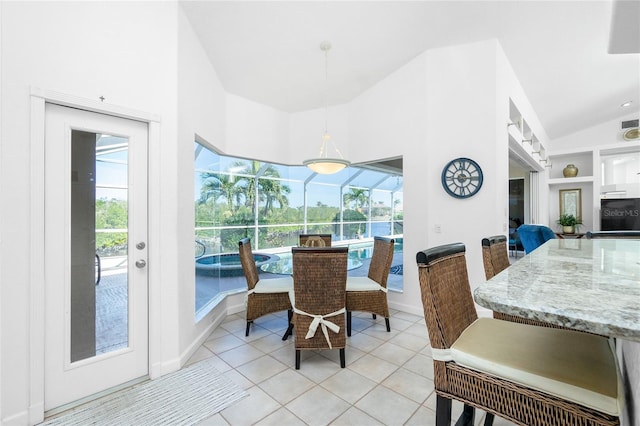 tiled dining area featuring plenty of natural light, built in features, and vaulted ceiling