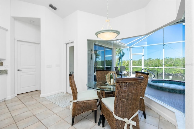 dining room featuring lofted ceiling and light tile patterned floors