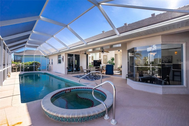 view of swimming pool with ceiling fan, glass enclosure, an in ground hot tub, and a patio