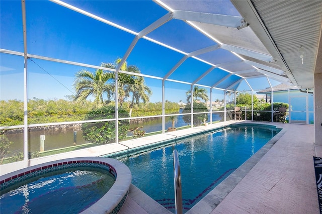 view of swimming pool with glass enclosure, an in ground hot tub, and a water view