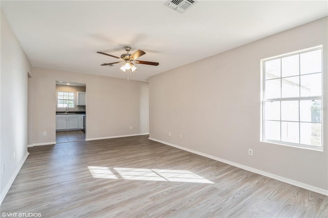 unfurnished room featuring ceiling fan, sink, and light hardwood / wood-style flooring