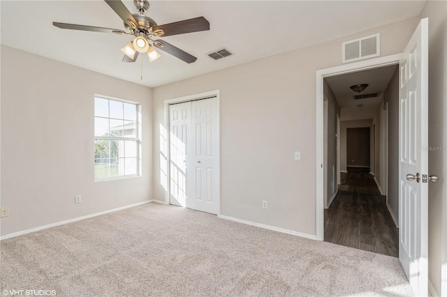 unfurnished bedroom with carpet, a closet, and ceiling fan