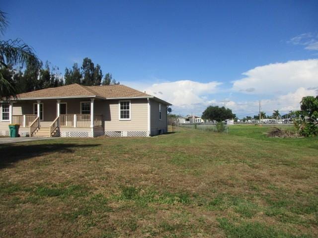 back of property with covered porch and a lawn