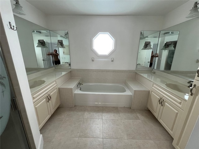 bathroom featuring tile patterned floors, tiled tub, and vanity