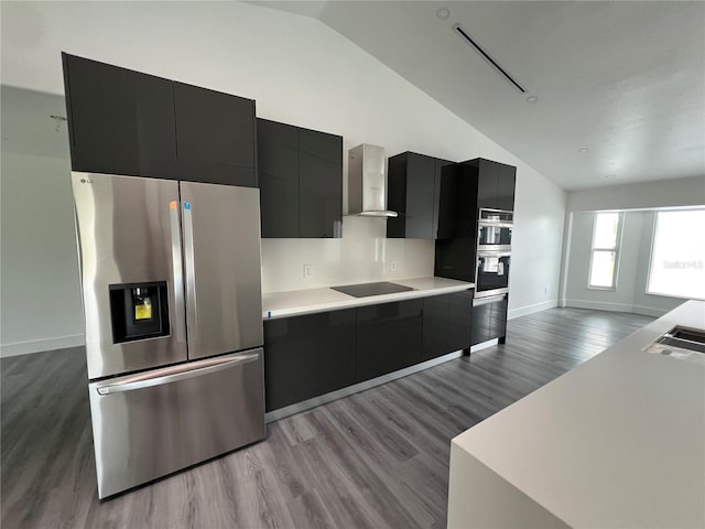 kitchen with wall chimney exhaust hood, stainless steel appliances, vaulted ceiling, and light wood-type flooring