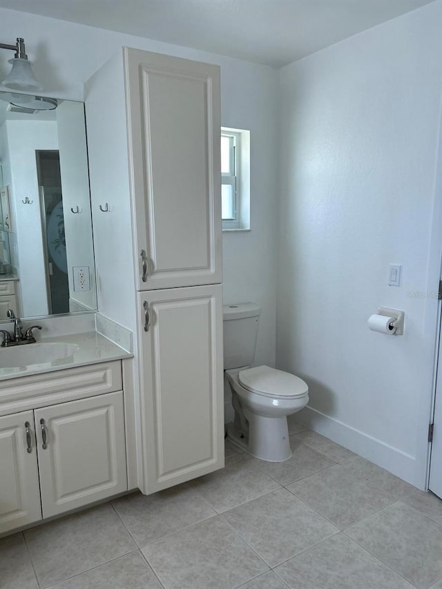 bathroom with tile patterned flooring, vanity, and toilet