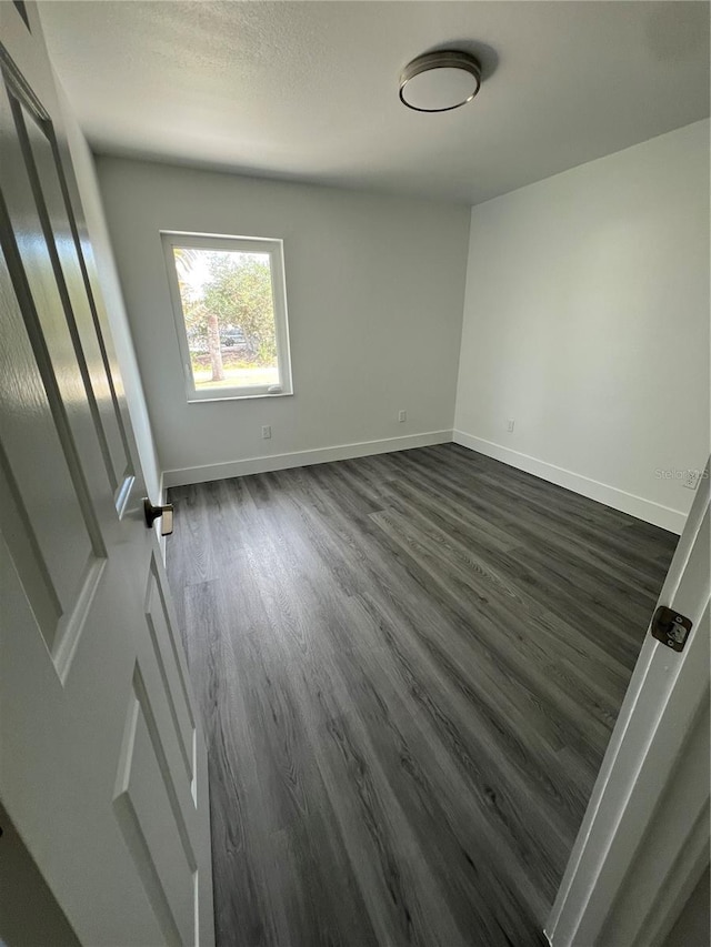 spare room with dark hardwood / wood-style floors