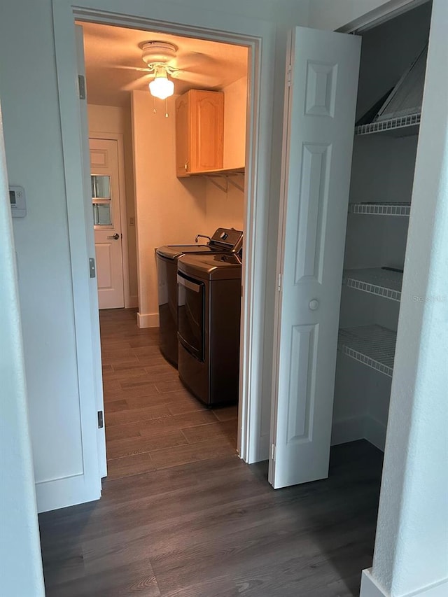 laundry area featuring cabinets, washing machine and dryer, and dark wood-type flooring