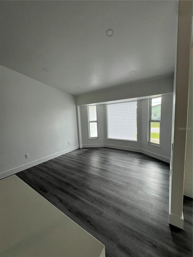 empty room featuring dark hardwood / wood-style flooring