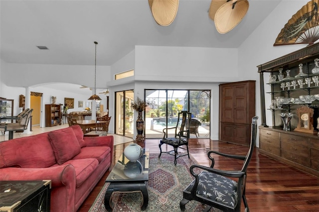 living room featuring dark wood-type flooring and high vaulted ceiling