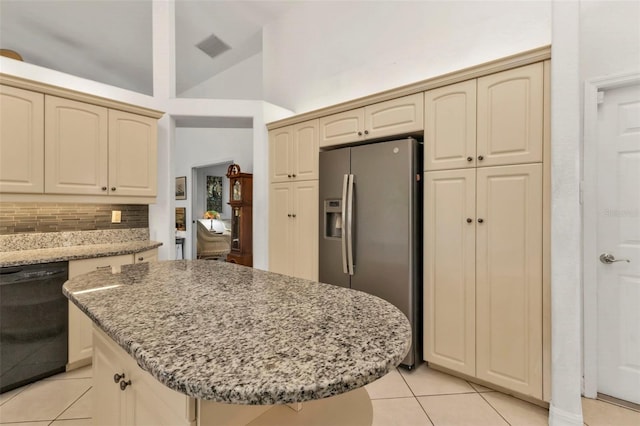 kitchen featuring stainless steel fridge with ice dispenser, cream cabinetry, dishwasher, light stone counters, and a center island