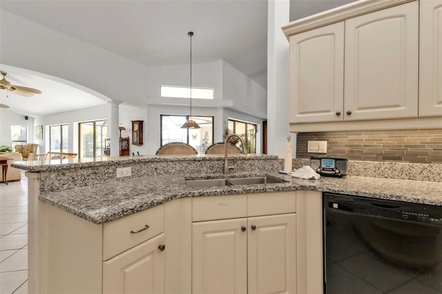 kitchen with dishwasher, sink, kitchen peninsula, cream cabinets, and vaulted ceiling