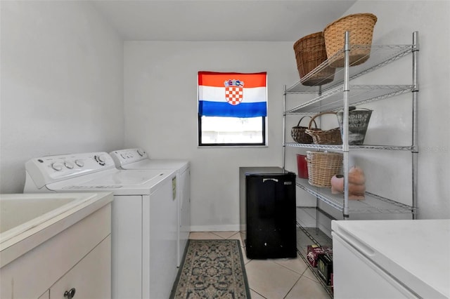 laundry area with light tile patterned floors and washing machine and clothes dryer