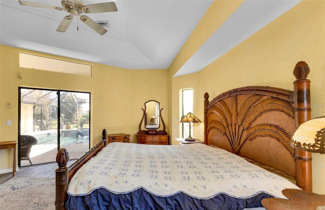 bedroom with ceiling fan, a tray ceiling, light hardwood / wood-style flooring, and access to outside