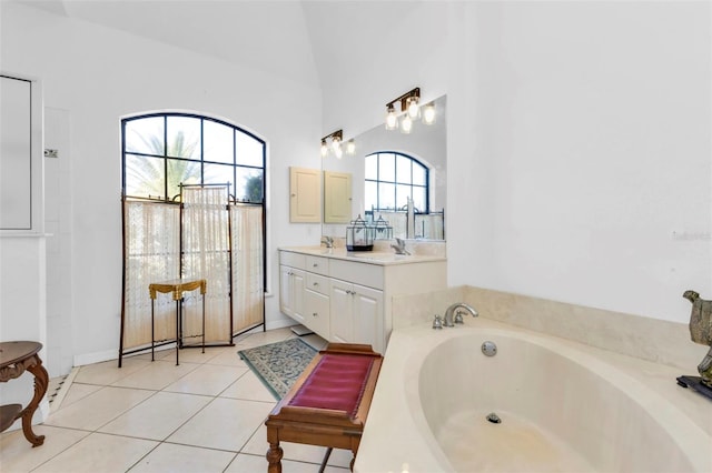 bathroom featuring a bath, tile patterned flooring, vaulted ceiling, and vanity