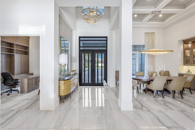 entrance foyer with coffered ceiling, an inviting chandelier, french doors, a towering ceiling, and beam ceiling