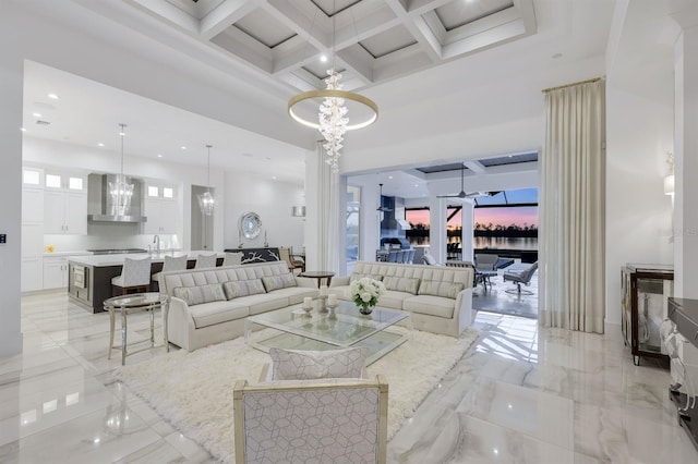 living room with beamed ceiling, an inviting chandelier, a towering ceiling, and coffered ceiling