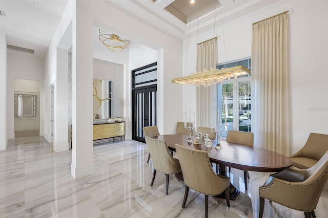 dining room featuring coffered ceiling, a towering ceiling, and a chandelier