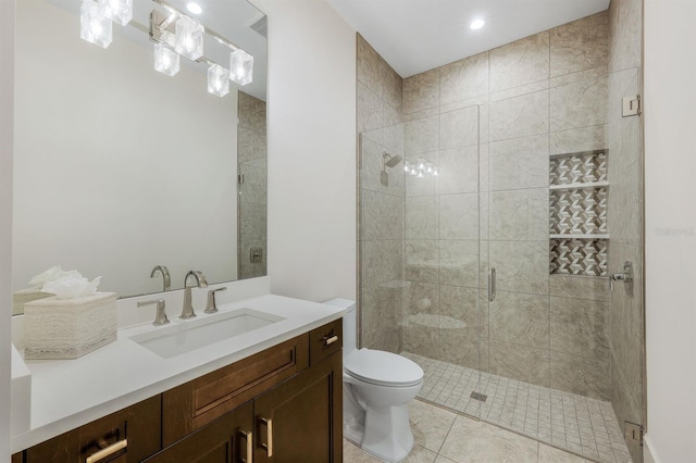 bathroom with tile patterned floors, vanity, toilet, and a shower with door