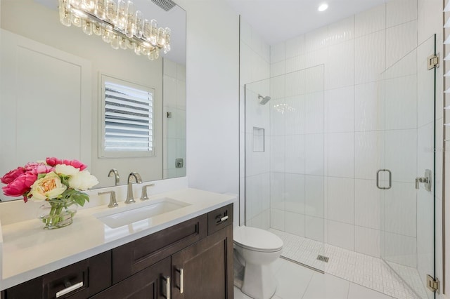 bathroom featuring vanity, a shower with door, an inviting chandelier, tile patterned flooring, and toilet