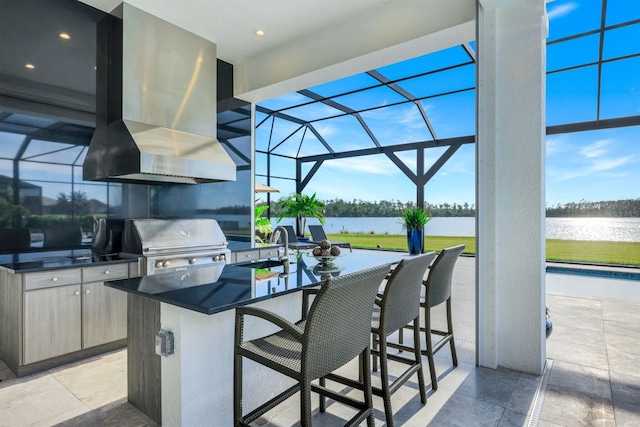 view of patio / terrace with glass enclosure, an outdoor kitchen, a grill, a water view, and a wet bar