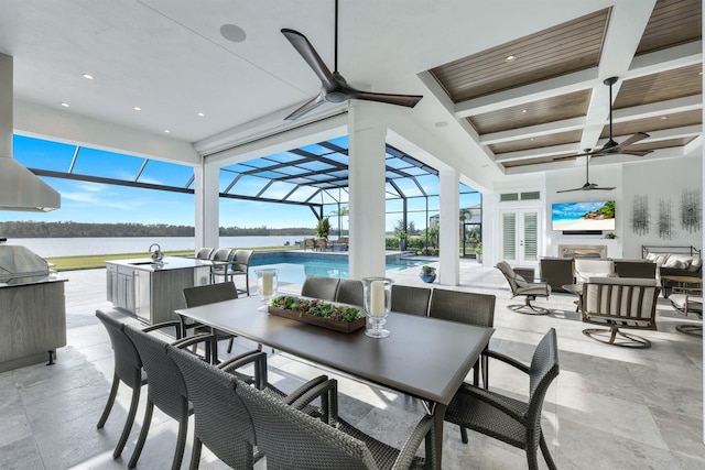 view of patio / terrace with glass enclosure, ceiling fan, french doors, an outdoor hangout area, and a water view