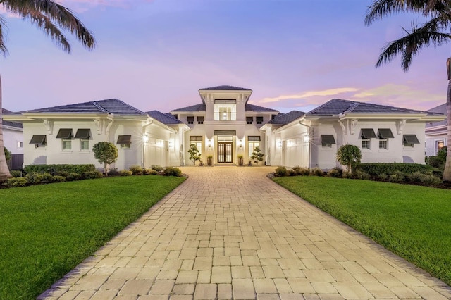 mediterranean / spanish house featuring french doors and a lawn