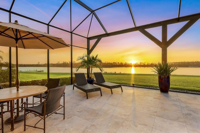 patio terrace at dusk with glass enclosure and a water view