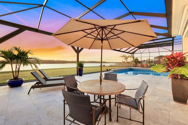 patio terrace at dusk with a water view and a lanai