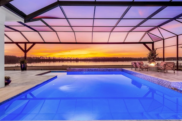 pool at dusk featuring a lanai, a patio, and a fire pit