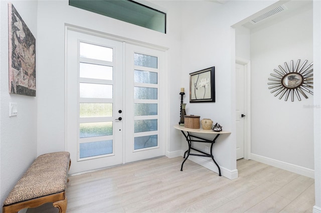 foyer entrance with french doors and light wood-type flooring