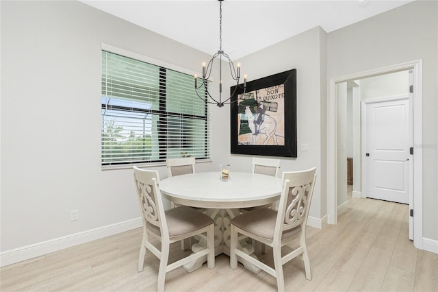 dining space with light wood-type flooring and a notable chandelier